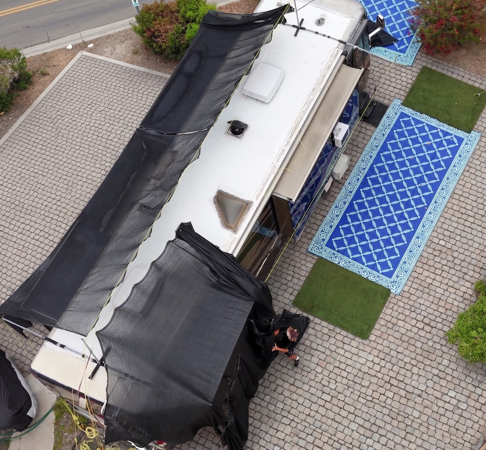 Massive shade fabric attached to hovershade frame canopy on a 40 foot RV retracted and pulled back like a curtain