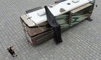 Man lifting a shade fabric from the ground pulling the lines up to the roof of an RV with an attached hovershade  frame canopy structure
