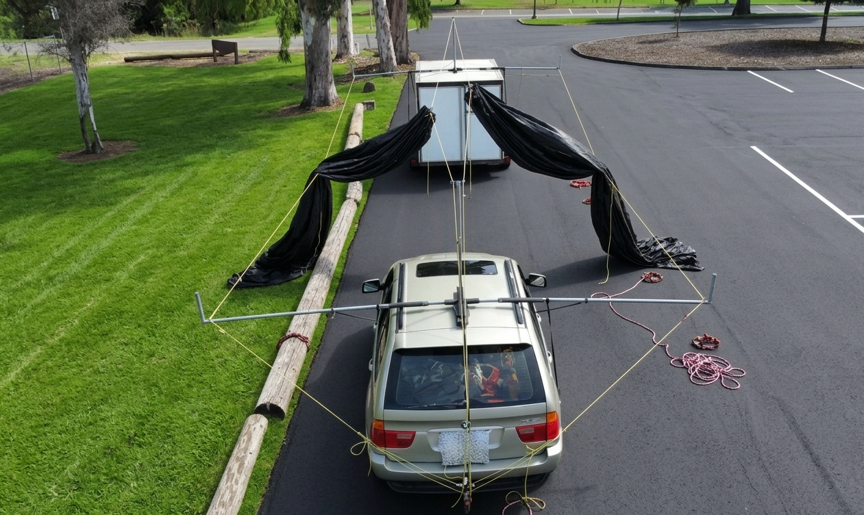 Shade frame canopy attached to a suv and a tow trailer with lines set up and shade ready to deploy